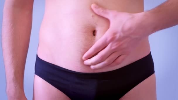 Mann in Unterhose berührt seinen schlaffen, fetten nackten Bauch, Nahaufnahme. — Stockvideo