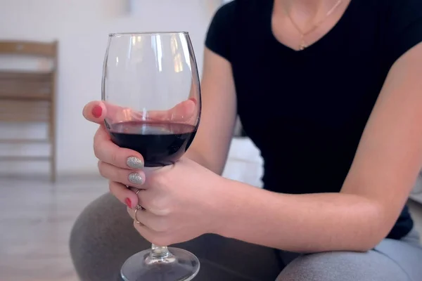 Frau mit einem Glas Rotwein in der Hand, Hände in Großaufnahme. — Stockfoto