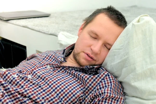 Man sleeps on the floor in living room. Hangover after a party.