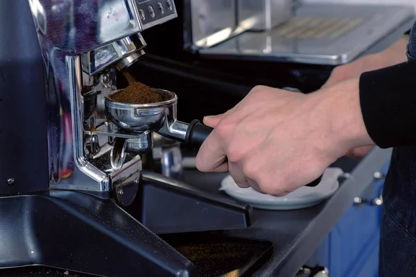 Бариста шлифовка кофейных зерен с помощью кофемолки и держатель. Руки крупным планом . — стоковое фото
