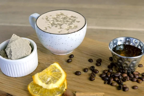 Чашка кофе с халвой подается на подносе с медом и кофейными зёрнами . — стоковое фото