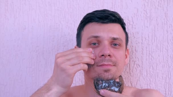 El hombre está aplicando mascarilla de coco casera fresca en la cara de la cáscara de coco . — Vídeos de Stock