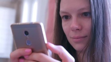 Portre genç kadın akıllı telefon online tarama internet sayfalarında kitap okur.