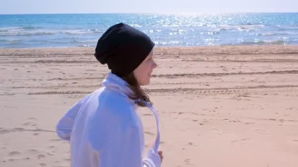 Щаслива дівчина біжить на морському піщаному пляжі портрет бігуна бігун спортивний одяг підходить на відкритому повітрі — стокове відео