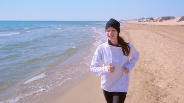 Retrato de mujer feliz trotando en el mar arena playa deporte correr al aire libre entrenamiento . — Vídeos de Stock