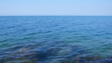 Gökyüzü, yan görünüm ile mavi ve berrak deniz suyu yüzeyi.
