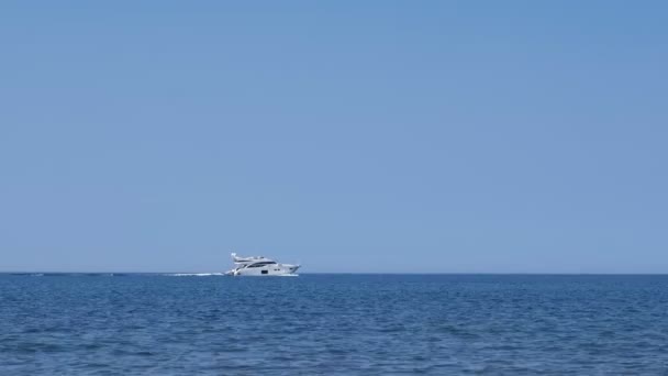 Λευκό γιοτ ιστιοπλοΐα στη θάλασσα σε καθαρή ηλιόλουστη μέρα, πλευρική θέα. — Αρχείο Βίντεο