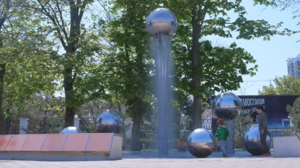 Anapa, Rusland, 26-04-2019: kinderen spelen in fontein met metalen ballen aan het water. — Stockvideo