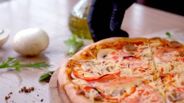 Cook sosis, mantar ve peynir pizza bir dilim alır. Lastik eldiven yakın çekim içinde el.
