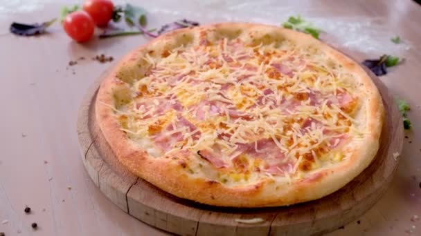 Pizza dengan bacon dan keju di papan kayu di atas meja. Tampilan samping close-up . — Stok Video