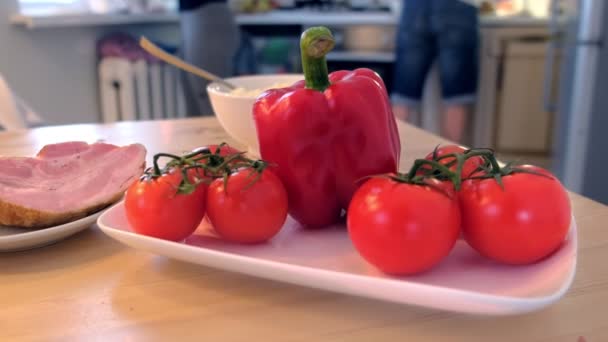 Pimienta, tomates y jamón en la mesa de la cocina. La familia está cocinando la cena en casa . — Vídeo de stock