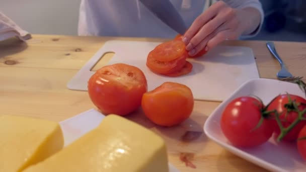 Kvinna nedskärningar tomater på plast ombord, händer närbild. — Stockvideo