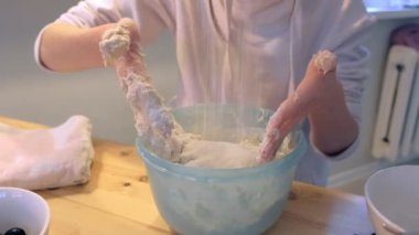 Kadın pizza hamuru kabın içinde kneads. Eller yakın çekim.