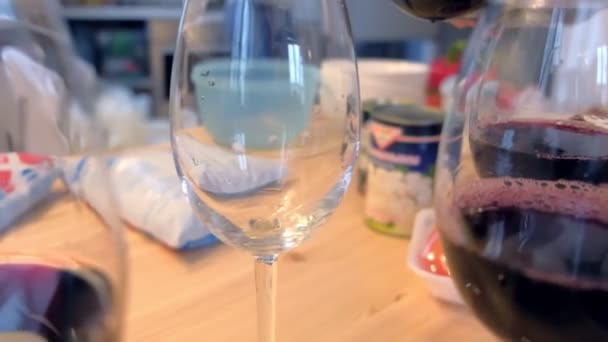 Κόκκινο κρασί είναι χύνεται wineglasses στην κουζίνα στο σπίτι. — Αρχείο Βίντεο