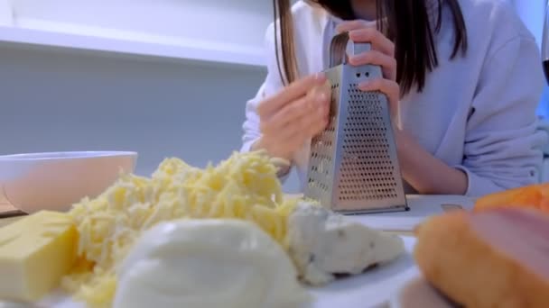 Kadın peynir rende evde mutfakta üzerinde losyonları. Eller yakın çekim. — Stok video
