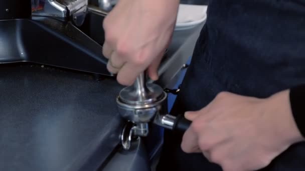 Barista presiona moliendo café en soporte para máquina de café. Primer plano de las manos . — Vídeo de stock