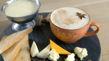 Eritilmiş peynirli peynirli peynirli kahve, peynir parçaları ve kara tepside ekmek tostları. Yakın çekim görünüm.