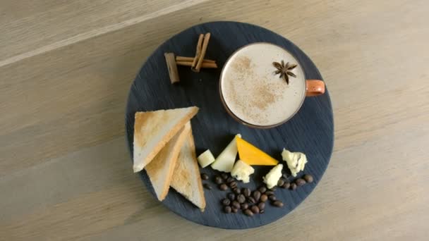 Ost kaffe med smält ost, bitar av ost och bröd skålar på en wod svart bricka. Ovanifrån. — Stockvideo