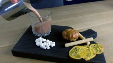 Barista sürahiden kaya camı içine kakao döker. Kakao pişirme. Eller yakın çekim.