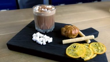 Kakao ile hatmi kaya cam pasta ve limon ile ahşap siyah tepside. Yakın çekim yan görünüm.
