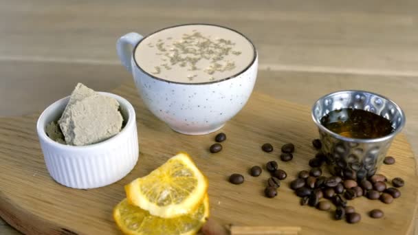 Tazza di caffè con halva servita su un vassoio con miele e chicchi di caffè. Vista da vicino . — Video Stock