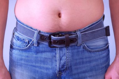 Şişman çıplak mide ile dar kot adam, bel closeup.