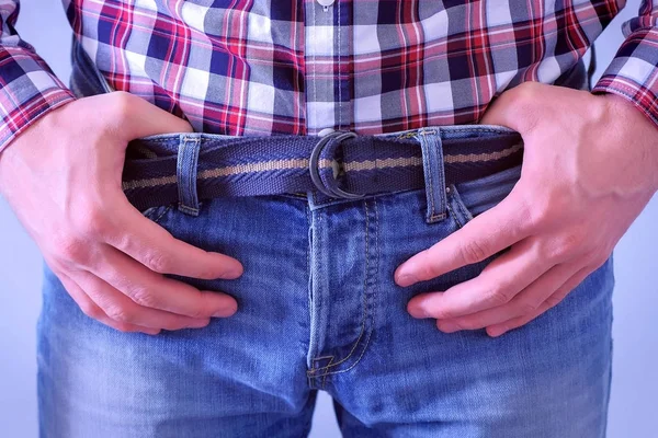 Cintura de homem em calça e camisa xadrez e umas mãos no cinto . — Fotografia de Stock