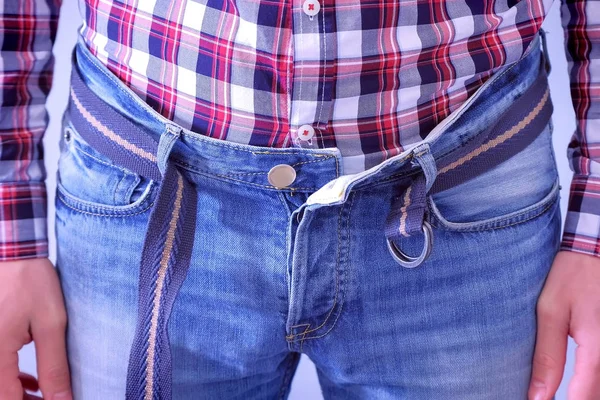 O homem mal aperta o cinto das calças de ganga, puxando o estômago, mãos fechadas . — Fotografia de Stock