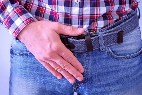 Мужчина трогает свой член в джинсах, держа за талию. . Лицензионные Стоковые Изображения