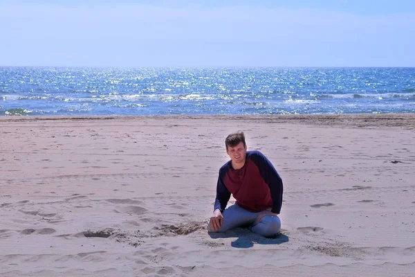 初心者疲れた男は、海辺でジョギングした後、砂浜に落ちる. — ストック写真