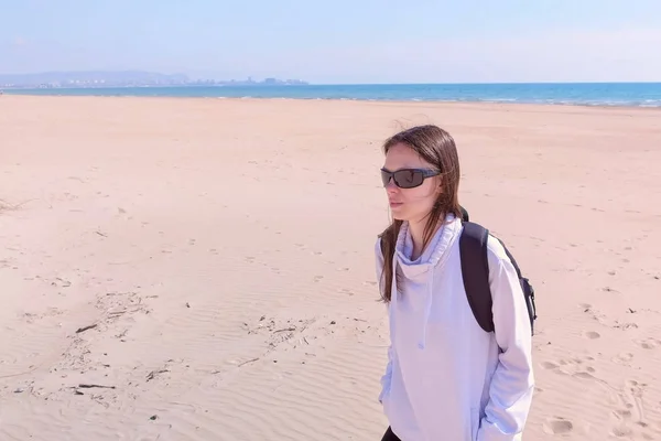 Cestovatelka chodí po mořském písku prázdná pláž mimo sezonu v dunách na dovolené. — Stock fotografie