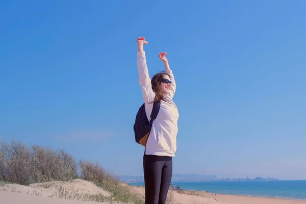 Lycklig kvinna höjer armarna upp på toppen av sanddyn på Sea Beach Winner koncept. — Stockfoto