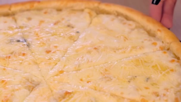 Femme prend une tranche de margarita pizza avec différents types de fromage sur planche en bois vue rapprochée . — Video