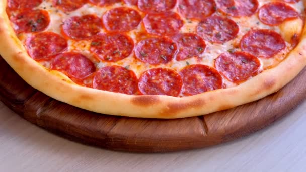 테이블에 나무 보드에 살라미 피자입니다. 클로즈업 보기. — 비디오