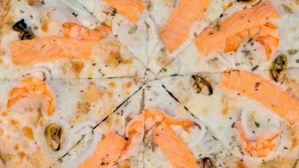 Εξάρτημα κοπής σε φέτες πίτσα με θαλασσινά και τυρί σε ξύλινο πίνακα, προβολή με μεγέθυνση. — Αρχείο Βίντεο