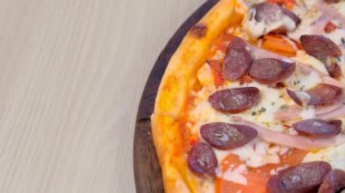 Füme sosis, jambon ve peynirli pizzanın yarısı. Yakın çekim üst görünüm.