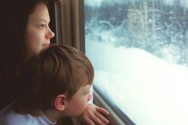 Anne ve oğlu penceresinde tren kış manzara üzerinde hareketli arıyoruz.
