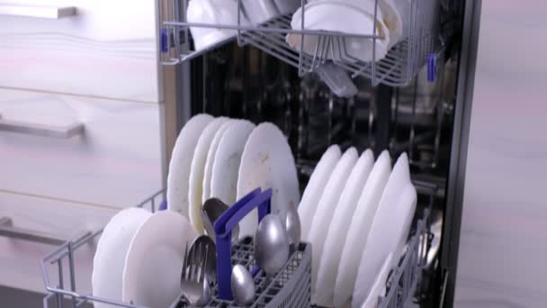 Vaatwasser manden met vuile witte borden en bestek in de keuken. — Stockvideo