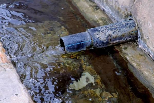 Water is poured out of the pipe. Storm drain pipe can not cope with the volume of water. Side view. — Stock Photo, Image