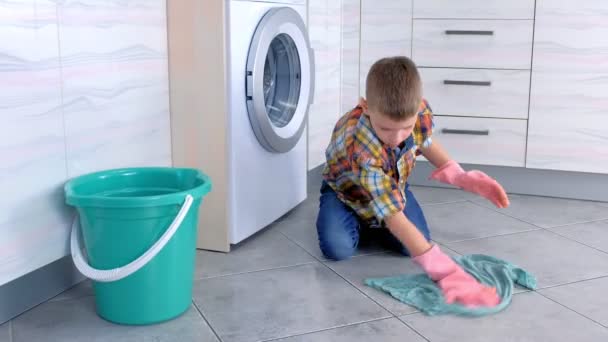 Chlapec v gumových rukavicích myje podlahu v kuchyni. Domácí poplatky za Childs. — Stock video