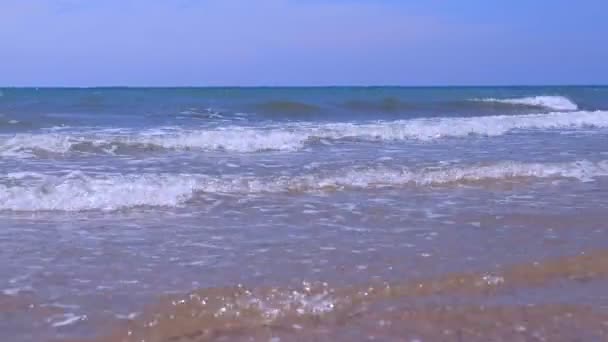 Closeup encaracolado longo espumoso rolando em ondas de tubo no mar tempestuoso no dia ensolarado . — Vídeo de Stock