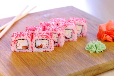 Üst üzerinde balık, karides ve kırmızı havyar ile rulo ahşap tahta wasabi ve soya sosu ile servis.