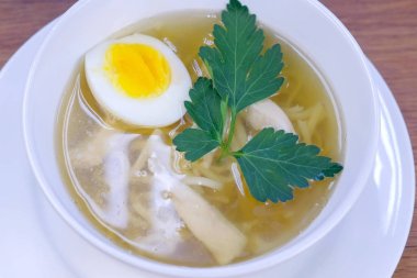 Tavuk çorbası erişte, yumurta ve Yeşiller beyaz kase.