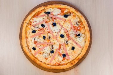 Masanın üzerinde tahta tahta üzerinde jambon ve peynir ile Pizza. Yakın çekim görünüm.