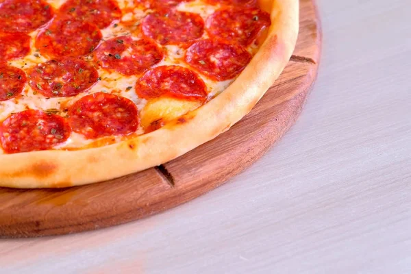 Viertel Salami-Pizza auf Holzbrett auf dem Tisch. Nahaufnahme. — Stockfoto