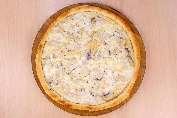 Pizza mit Champignons und Käse auf Holzbrett auf dem Tisch. Nahaufnahme von oben. — Stockfoto