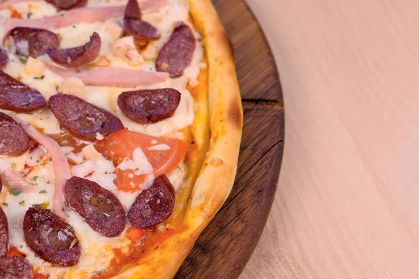 Eine Viertelstunde Pizza mit Räucherwurst, Schinken und Käse. Nahaufnahme von oben. — Stockfoto