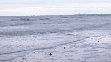 Fırtınalı dalgalar deniz köpüğü ile. Kum plaj kışın.