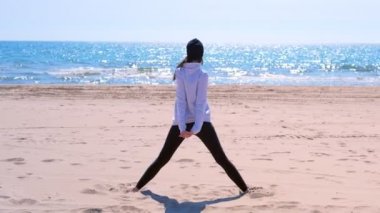 Kadın üçgen yoga fit geri görünümü için kum denizi plaj spor egzersiz poz yok.