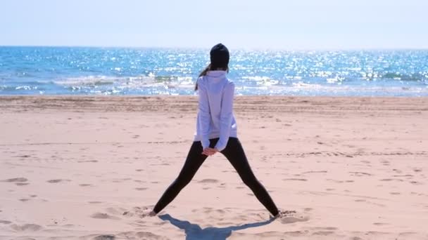 Woman does triangle yoga pose sand sea beach sport exercise for fit back view. — Stock Video